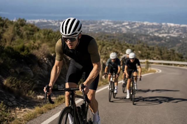 Road cyclists climbing a long mountain road above Marbella on a clear morning