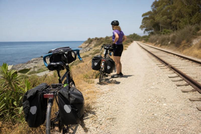 Touring bikes resting beside the old railway path with the coast in the distance
