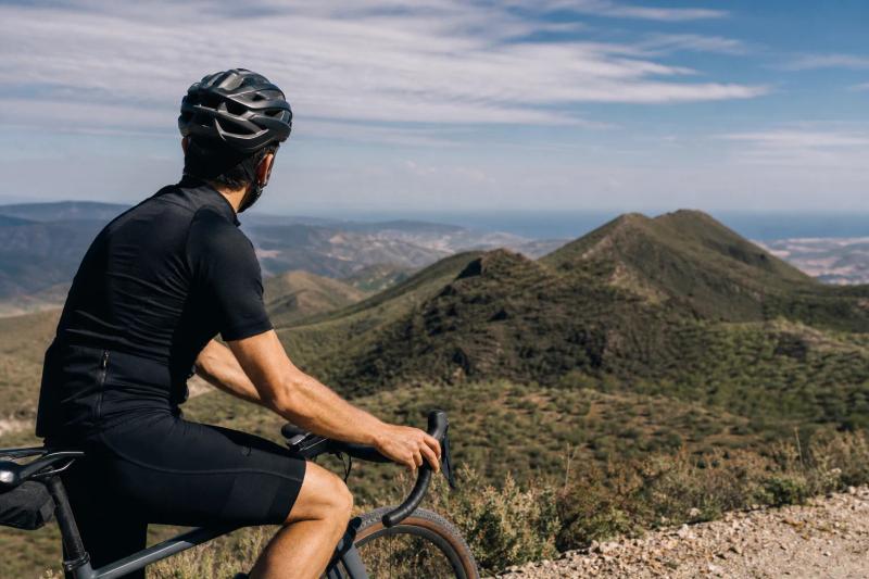 Cyclist on a gravel bike looking across extinct volcanoes on a ride from Marbella