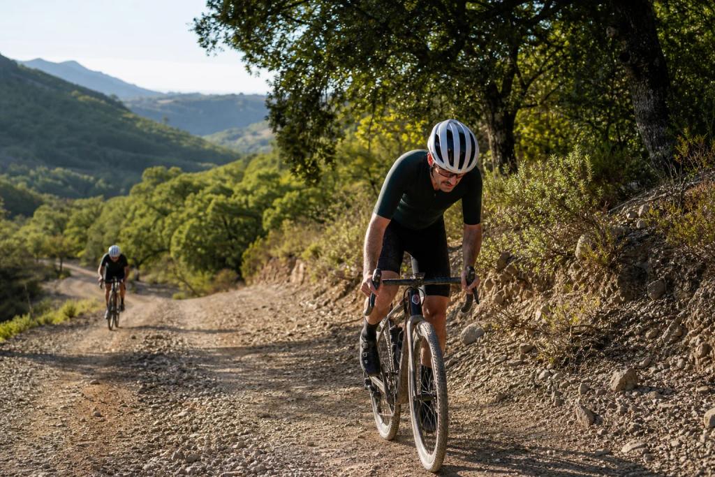 Gravel riders climbing a loose track across open volcanic ground near Marbella